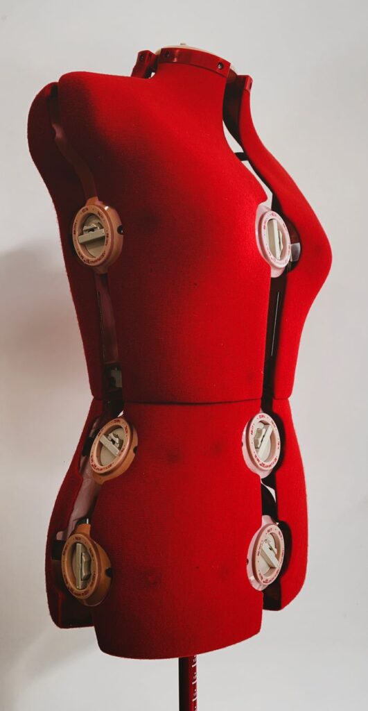 Close-up view of a red mannequin showcasing fashion design details.