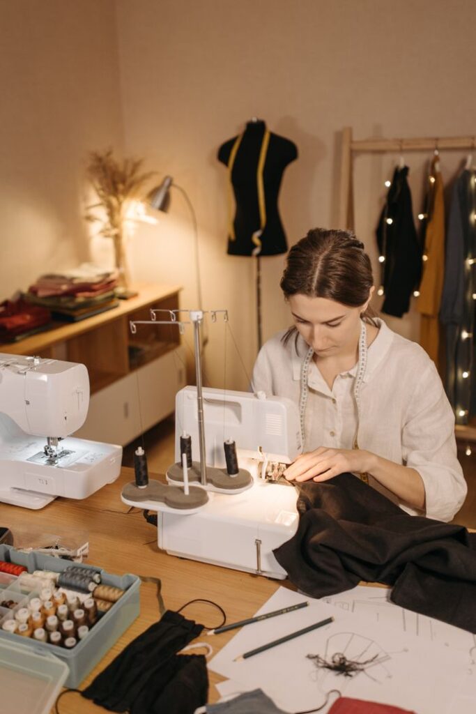 A seamstress skillfully sewing fabric with a machine in a well-lit studio. Ideal for small business and crafts themes.